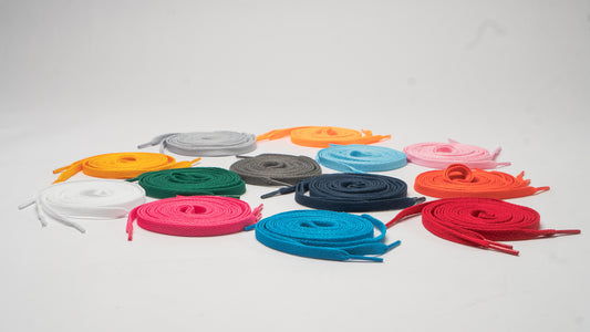 Assorted colorful shoelaces arranged in a circular pattern on a light gray background